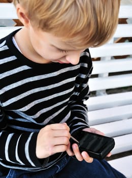 little boy using smartphone with stylus
