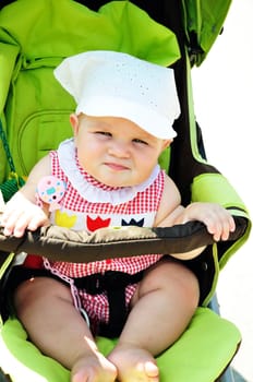 serious  baby girl sitting in the storller