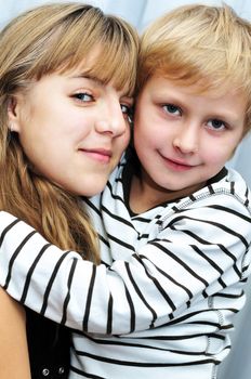  Brother and sister at home smiling and embracing
