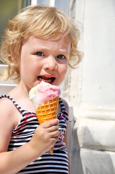  little girl outdoors eating huge ice cream cone
