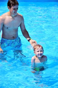 father and son having fun in swimming pool