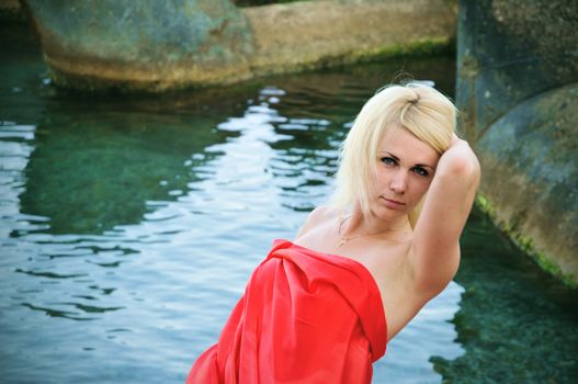 lady in red standing on the beach

