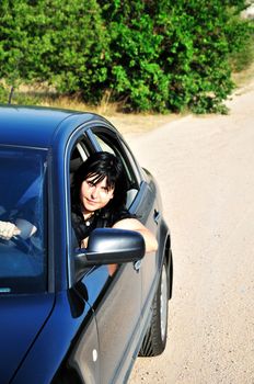 oung brunette woman driving a car outdoors
