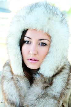pretty brunette with hazel eyes is wearing winter fur cap