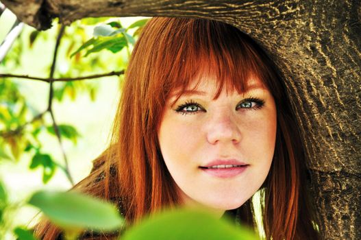 face of spring redheaded girl under the green tree