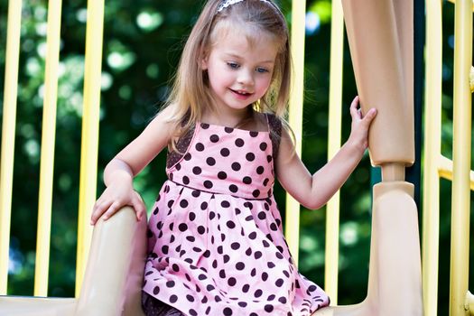 Beautiful little girl playing at the playground.