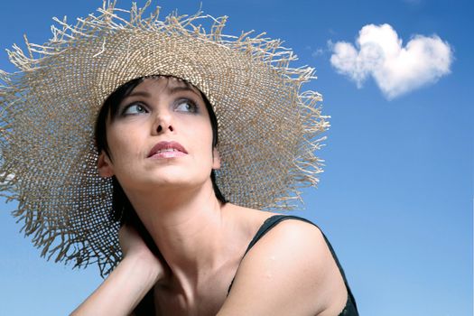 Dreaming woman with blue sky and heart shaped clouds