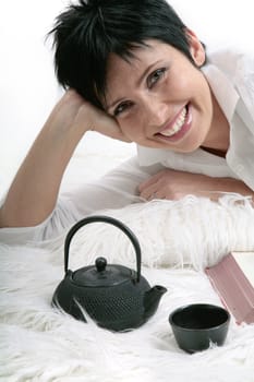 Young pretty woman smiling and drinking tea