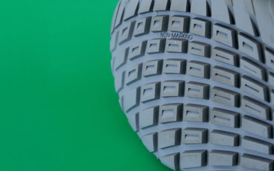 macro pattern of rubber sole of sneakers against green