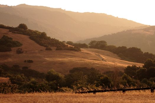 smoke from nearby fires bring a brown haze to the foothills just before sunset