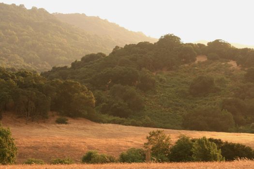 smoke from nearby fires bring a golden haze to the foothills just before sunset