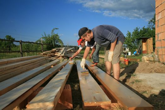 painters painting the wooden logs