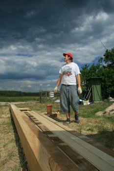 painter painting the wooden logs