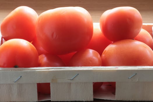 Some red tomatoes in the wooden box