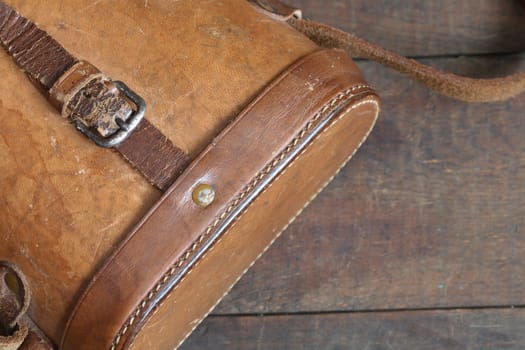 Closeup of antique ginger leather case on wooden background