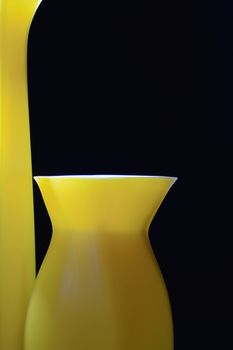 Closeup of nice modern yellow vases isolated on black background
