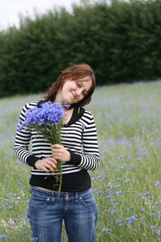 Young woman with flowers, meadow