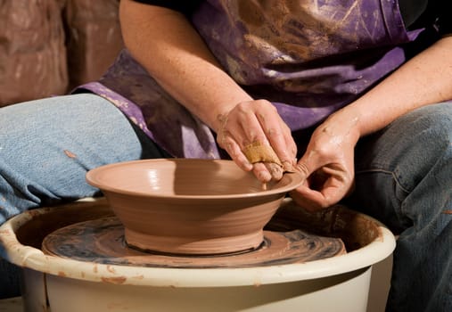 Female Potter Shaping Clay on Wheel in Studio