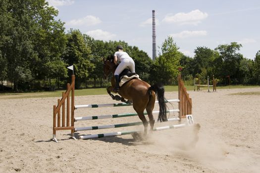 horse with  rider jumping over obstacle during jumping contest