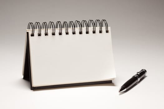 Blank Spiral Note Pad and Pen on a Gradated Background.