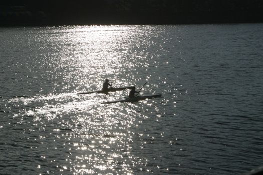 couple kayaking, with reflection.