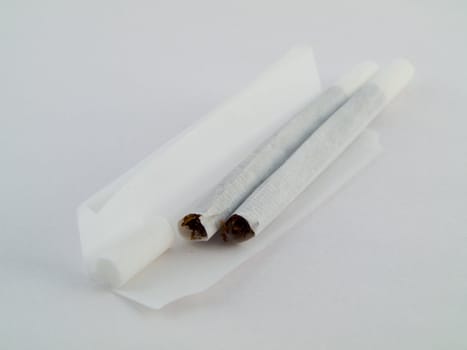 Two 2 Hand Rolled Cigarettes With Filters on Whtie Background