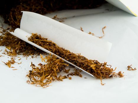Hand Rolling Tobacco and Hand Rolled Cagarettes on White Background