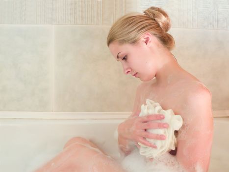 young beautiful girl in a bath with shower