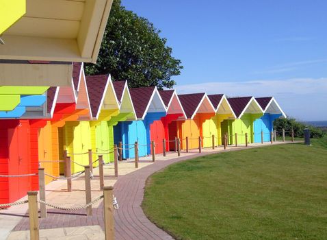 Exteriors of beautiful bright seaside beach chalets, Scarborough, England.