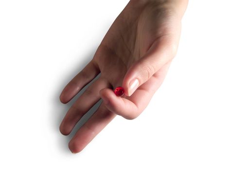 red capsule in woman hand. Isolated on white