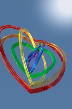 six heart shaped plastic pieces one inside the other on a sunny background as if floating on air