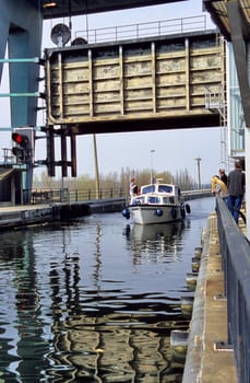 A pleasure boat motors through locks. The inclined plane boat lift at Ronquieres, or sloping lock, raises and lowers boats and barges 68m or 223ft in about 90 minutes on the Brussels - Charleroi canal on a system of rails.