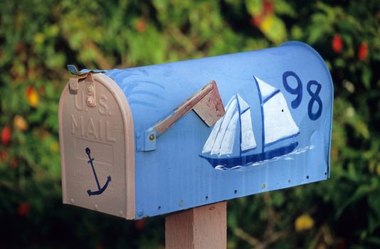 A cheerful mailbox hand painted with a sailboat.