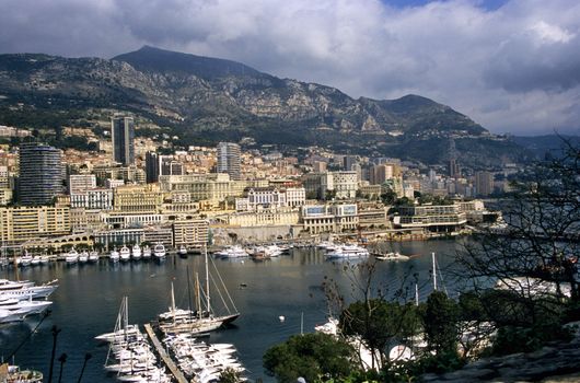 Luxury yachts dock in Monaco, home of the Monaco Grand Prix and Monte Carlo Casino, visible in the background.