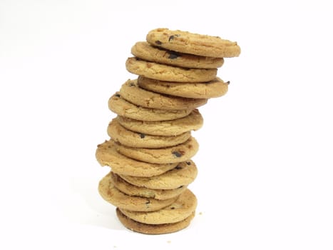 Large stack of chocolate chip cookies on a white surface
