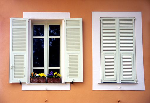 An orange house with white shutters in Monaco.