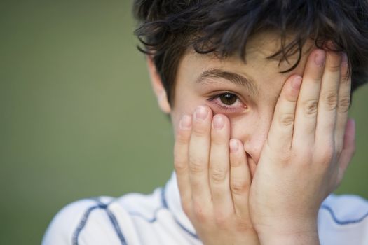 Portrait of a Young Teen Boy with Dark Curly Hair Covering His face