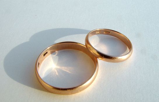 Two wedding gold rings on white background