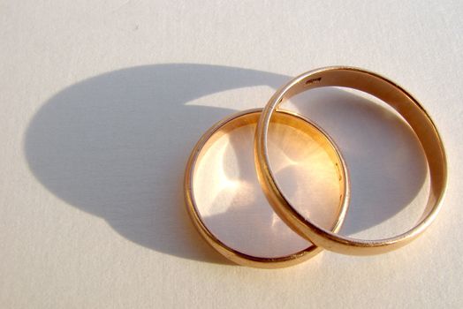 Two wedding gold rings on white background