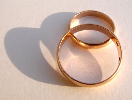 Two wedding gold rings on white background