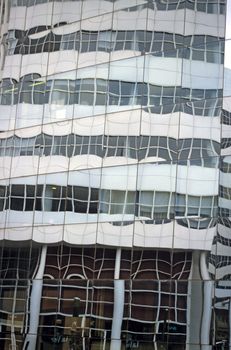 Reflection of a modern office building in the mirrored glass of another office tower.