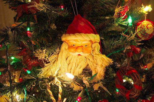 santas head amongst the christmas tree lights
