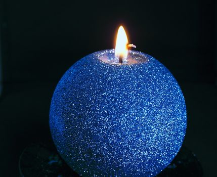 blue ball candle against a black background