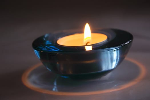 one tealight candles in a blue glass holder