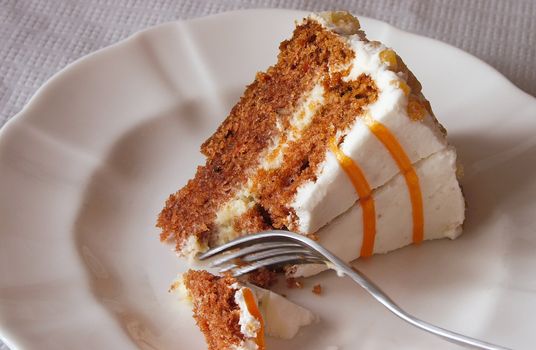 piece of carrot cake being cut with a fork