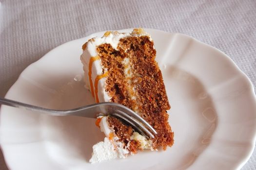 carrot cake being cut through with a fork