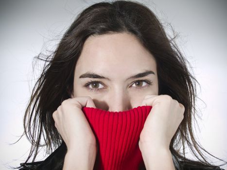 Portrait of a beautiful model holding her red sweater neck.