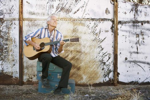 Handsome man playing an old acoustic guitar