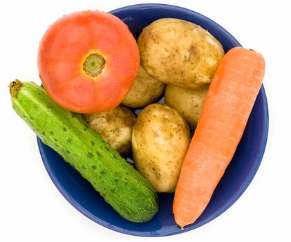 Potatoes, cucumber, tomato, carrots. Plate with vegetables on a white background.