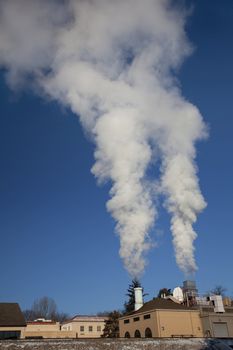 two smoke and steam plumes from a small heating plant on cold winter mornings at Colorado State University campus, Fort Collins